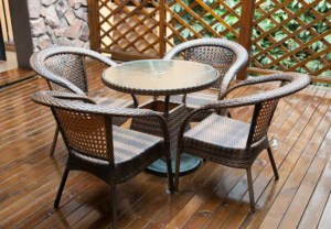 Braune Rattanstühle in Sesselform mit runden Rattan Glastisch (depositphotos.com)